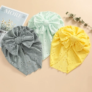 Detailed view of three baby turbans featuring hollow knit patterns and oversized bows