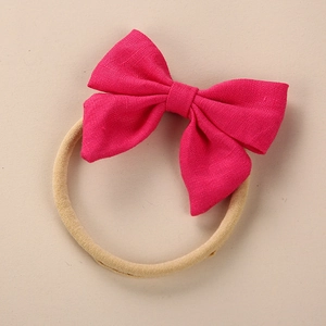 Detail of fuchsia linen bow on soft nylon headband for babies and infants