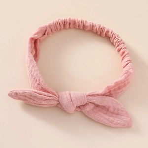 Detail of pink cotton crepe baby headband featuring bunny ear bow and elastic band
