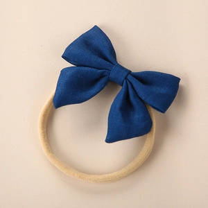 Close-up of dark blue linen bow headband for babies with soft nylon elastic band