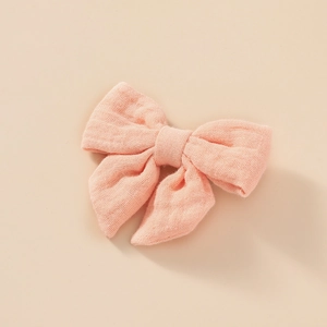 Détail de la texture d'une barrette en mousseline de coton de couleur rose poudré