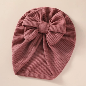 Detail of pink waffle knit baby turban hat with a large decorative bow for newborns