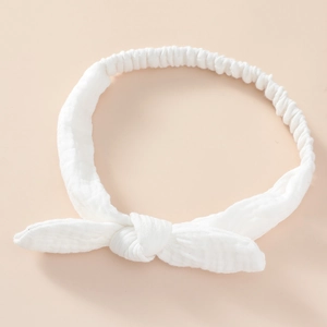 Detail of white cotton baby headband with bow knot and textured fabric finish