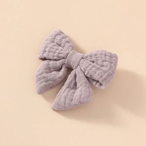 Détail de la pince à cheveux noeud en gaze de coton mauve avec texture gaufrée double
