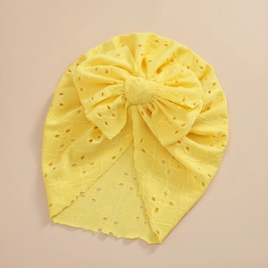 Detailed view of yellow baby turban hat featuring hollow embroidery and a large bow
