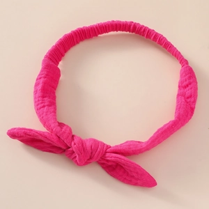 Close-up of bright pink cotton bunny ear headband with soft knot texture for infants