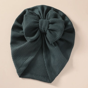 Detail of baby waffle knit hat with oversized double-layered bow in forest green color