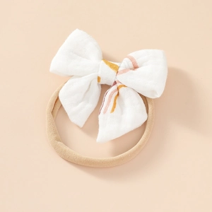 Detail of soft cotton baby headband with white printed bow and elastic nylon band