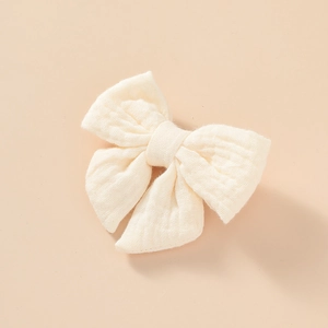 Gros plan sur le nœud en gaze de coton mousseline crème montrant la texture du tissu