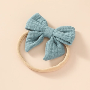 Close-up of baby headband with a large teal cotton bow and soft seamless nylon band