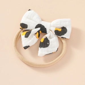 Close-up of baby headband with a soft leopard print cotton bow and stretchy nylon strap