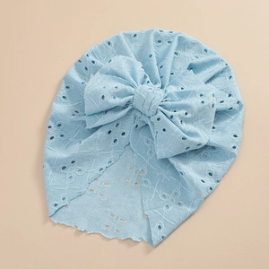 Detailed shot of baby turban with large bow in light blue eyelet lace fabric