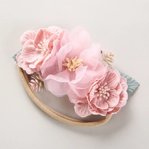Detailansicht der rosa Stoffblumen und Netzblütenblätter auf dem Baby-Nylonstirnband