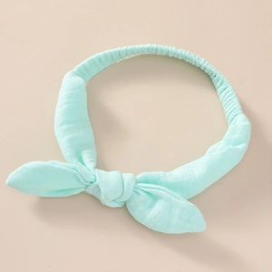 Detail of mint green cotton baby headband featuring a knotted rabbit ear bow design