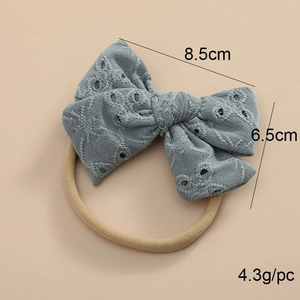 Détail du nœud en dentelle bleue de 8,5cm sur bandeau bébé en nylon nude