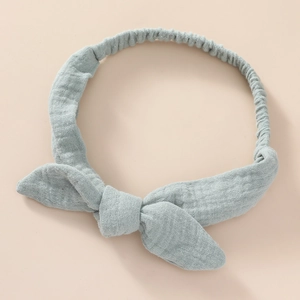 Detail of baby headband featuring soft wrinkled light blue cotton fabric and large bow