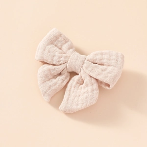 Vue détaillée du nœud papillon en mousseline de coton pour enfant à texture douce