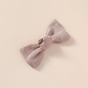Détail d'un nœud papillon en lin fait main pour cheveux de couleur vieux rose poudré