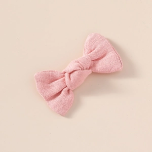 Détail d'un nœud papillon en lin rose montrant le nœud fait main et le tissu tissé