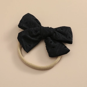 Détail d'un nœud en dentelle noire avec broderie creuse et cordon en nylon élastique