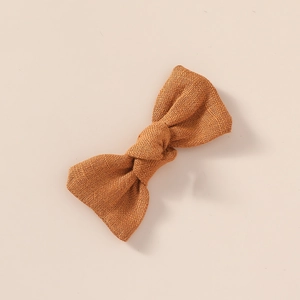 Texture détaillée d'un nœud papillon en lin caramel avec tissage naturel du tissu