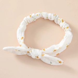 Detailed view of white floral cotton headband with rabbit ear bow and elastic texture