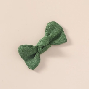 Détail macro du n?ud pour cheveux en lin vert forêt montrant la texture du tissu