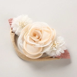 Detail eines Baby Stirnbands mit großer rosa Stoffrose und kleinen weißen Perlenblumen