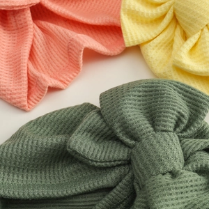 Three-pack waffle knit newborn hats with knots in pink, yellow and green colors