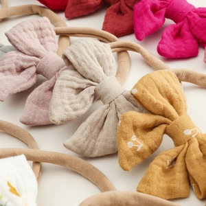 Detail of soft cotton baby headbands featuring colorful bows and elastic nylon bands