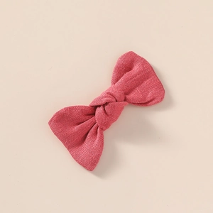 Détail du nœud papillon en lin fait main rose foncé avec texture de tissu noué