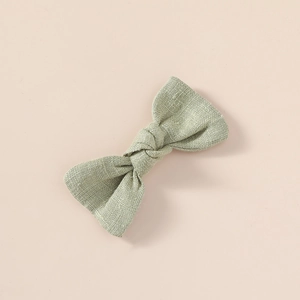 Détail de la barrette à nœud en lin vert sauge avec texture en coton premium