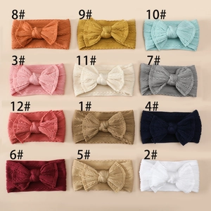 Detail showing 12 colors of soft knit nylon baby headbands with large bows for infants