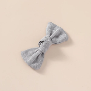 Détail de la texture en lin gris d'une barrette à nœud faite à la main pour filles