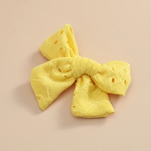 Détail d'un nœud papillon jaune vif avec broderie en dentelle ajourée pour enfants