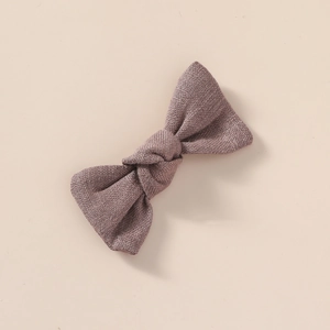 Gros plan détaillé sur un nœud à cheveux en lin mauve texturé avec design fait à la main