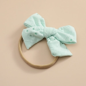 Détail du nœud en dentelle vert menthe avec bandeau élastique souple en nylon bébé