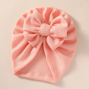 Pink waffle knit baby turban hat featuring a large double layer bow for newborns