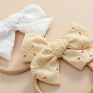Vue détaillée de bandeaux en dentelle souple blanche et beige avec ruban en nylon doux
