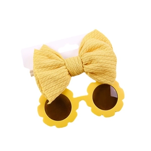 Yellow kids striped bow headband and flower shaped sunglasses set on white background