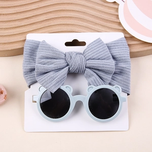Detail view of grey ribbed bow headband and blue bear ear sunglasses set for babies