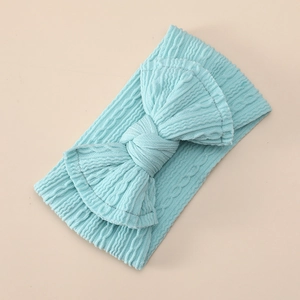 Detailed view of baby light blue ribbed knit headband with a large decorative soft bow