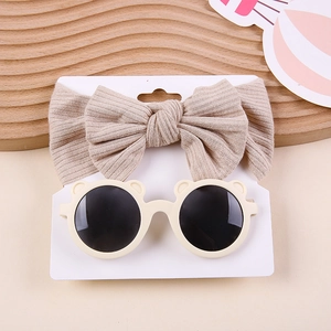 Detail of beige ribbed bow headband and cream bear-ear sunglasses set for babies