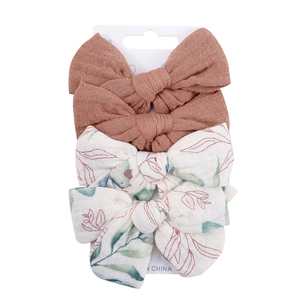 Detailed view of 4-piece cotton bow hair clips set on display card for infants