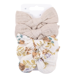 Detail of 4-pack baby cotton bow hair clips with floral and beige patterns on display card