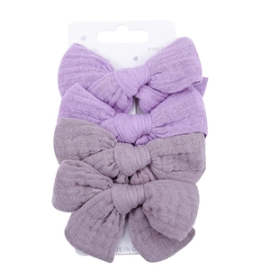 Detail view of 4-piece set cotton bow hair clips on white display card for babies