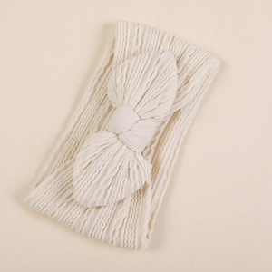 Détail du bandeau en jacquard de nylon crème avec un grand nœud papillon texturé