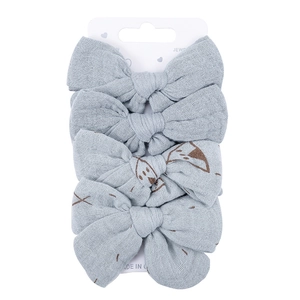 Detail view of 4-piece light blue cotton bow hair clips on a white display card