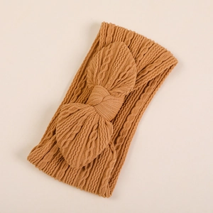 Détail d'un bandeau pour bébé en nylon jacquard marron clair avec nœud tricoté texturé
