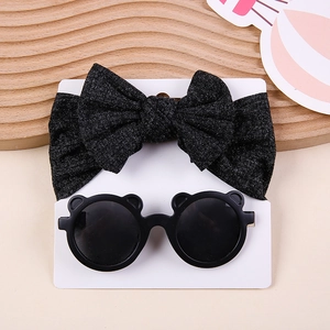 Detail of dark grey bow headband and black bear sunglasses on display card